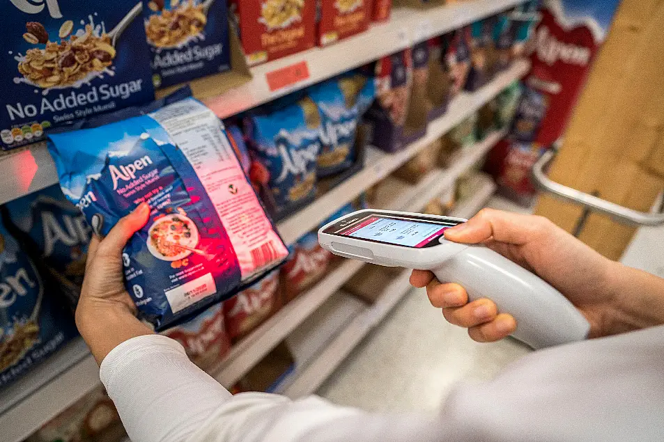 Someone using a supermarket scanner (Alamy/PA)