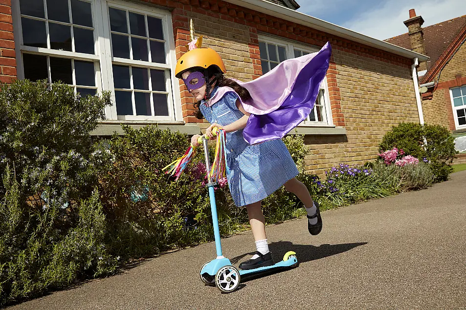 Girl riding a scooter to school