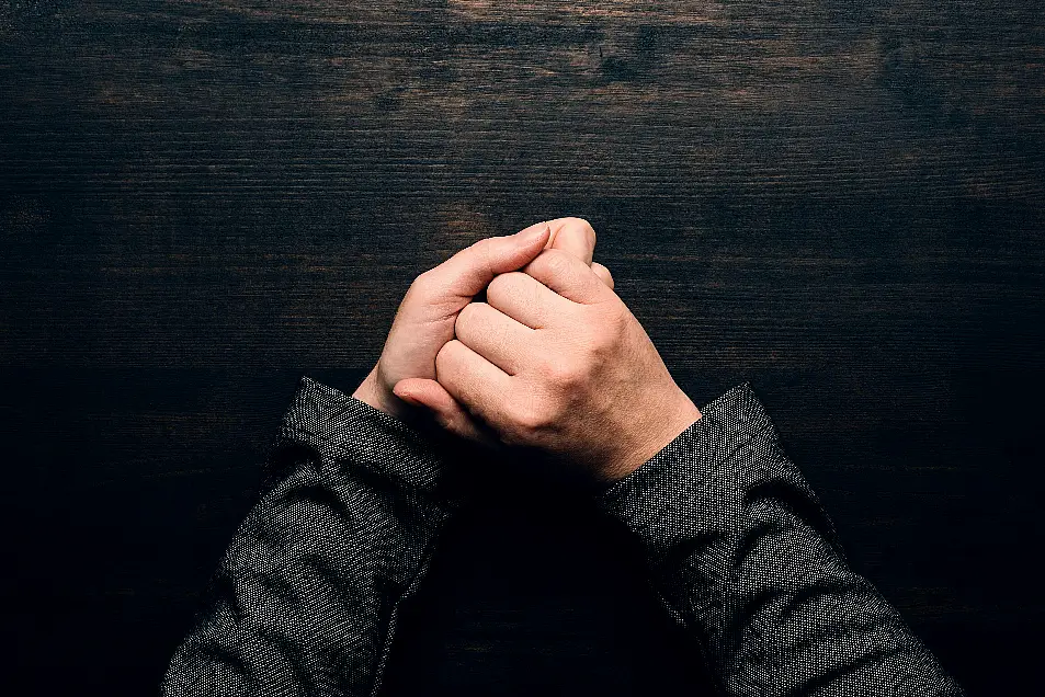 hands wringing at office desk