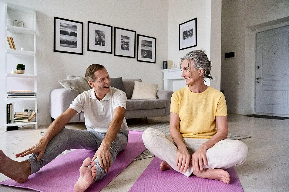 Fit active mature wife and senior husband having fun exercising at home.