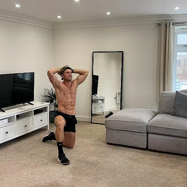 Henry Myers kneels on the floor as he worksd out at home (Henry Myers/PA)