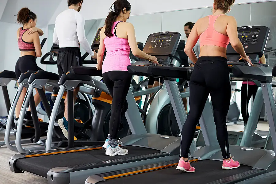 People Using Equipment In Busy Gym