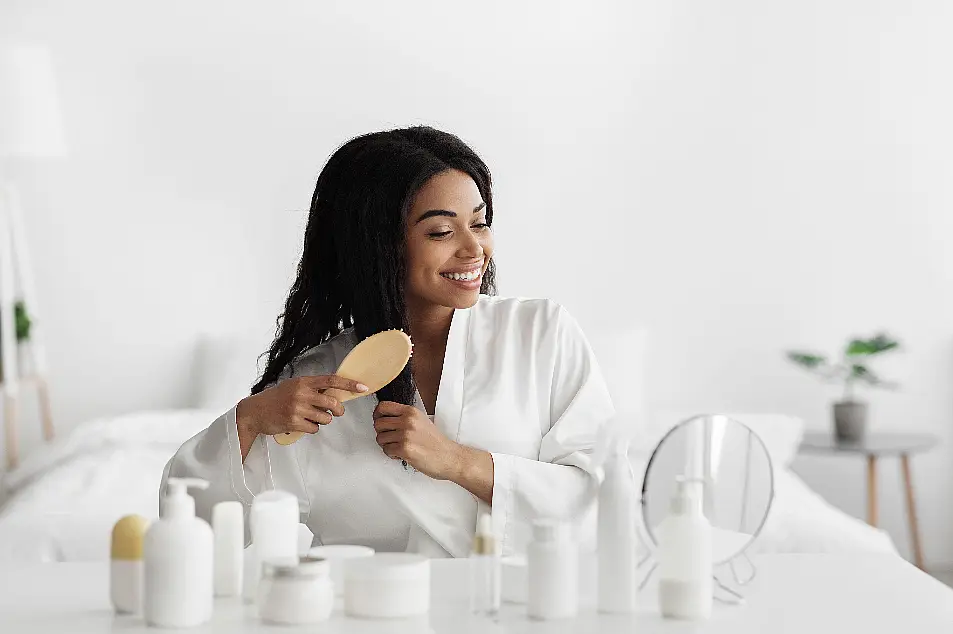 woman brushing her hair in front of the mirror