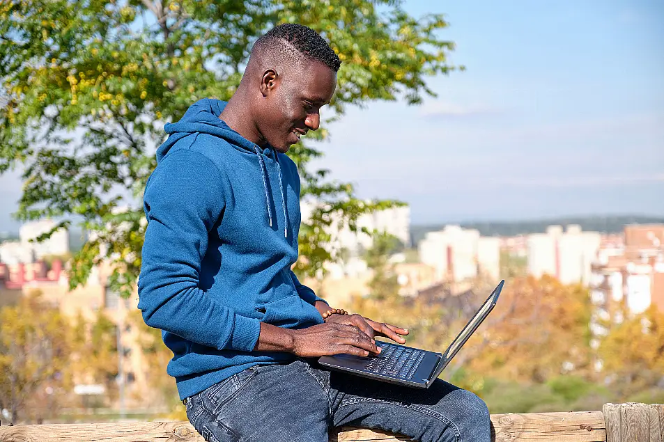 man working outside on laptop