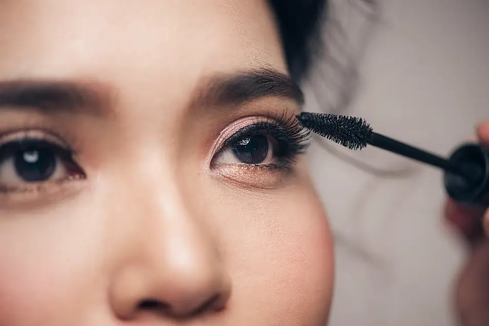 woman applying black mascara