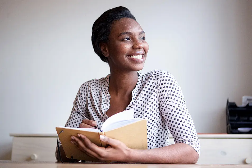 Woman writing in journal at home