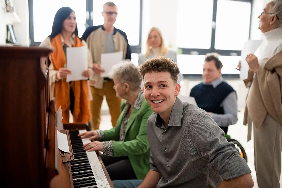 adult choir singing at piano