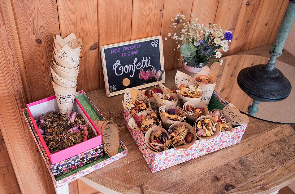 rose petal dried confetti at a wedding on a table for guests