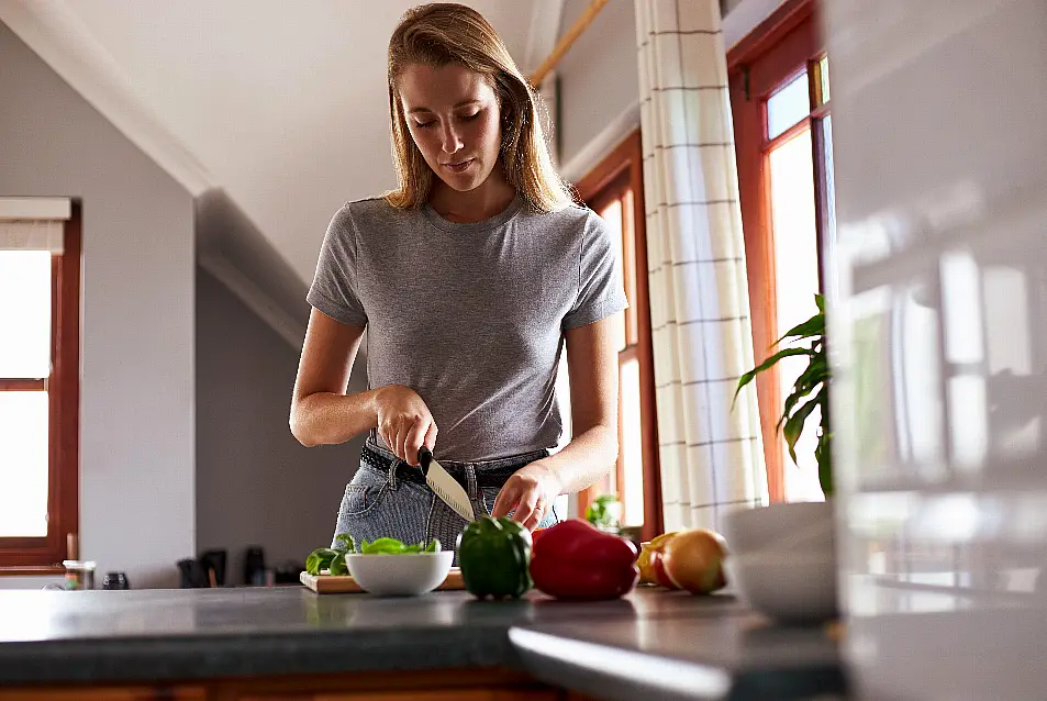 Young woman preparing vegan dinner in kitchen at home.