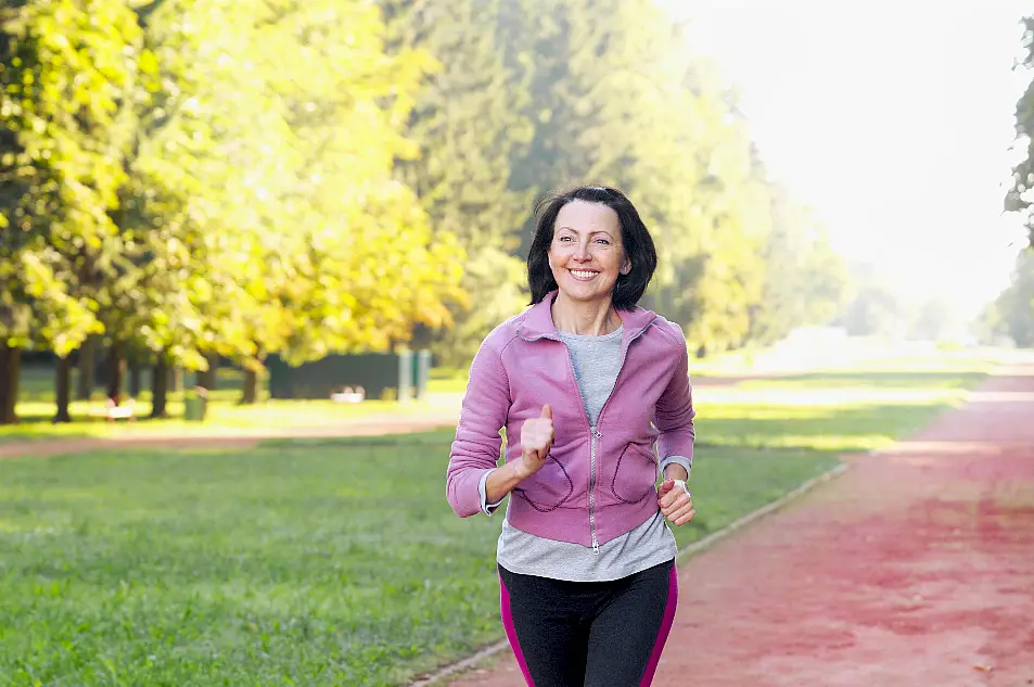 A middle-aged woman running in a park 