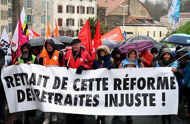 Demonstrators from unions hold a banner reading in French “withdrawal of this unfair pension reform” during a demonstration in Bayonne, southwestern France