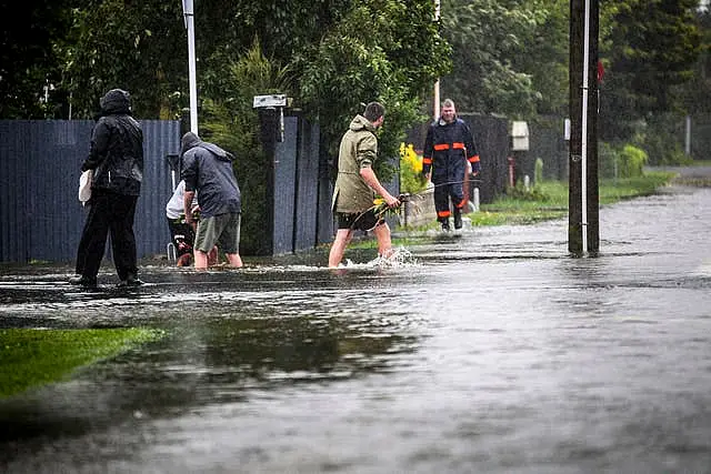 People walk through flood water in Hastings, southeast of Auckland