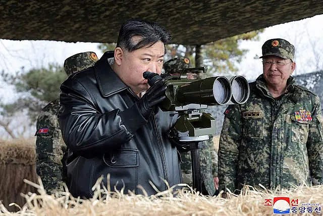 Photo provided by the North Korean government showing leader Kim Jong Un, left, supervising artillery firing drills 