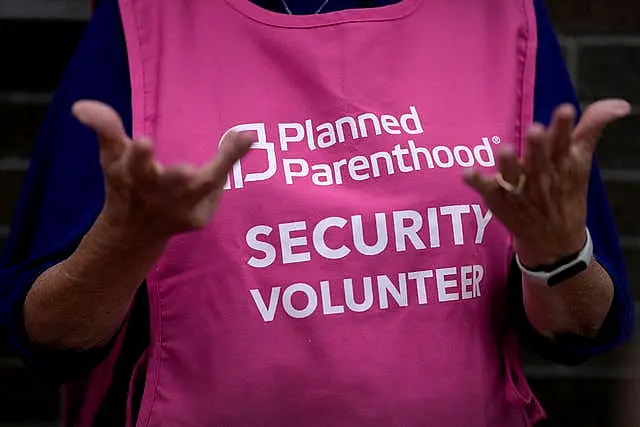 A Planned Parenthood clinic patient escort stands outside the building in Iowa