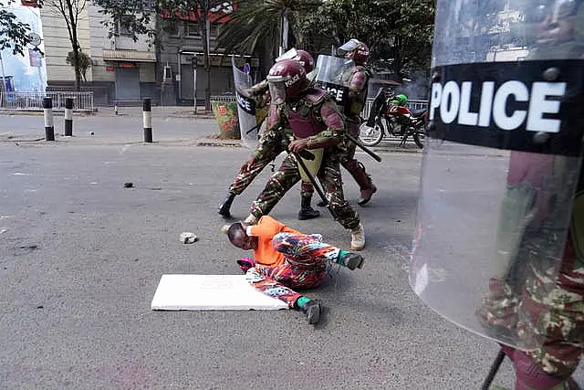 Kenya police take on a man during a protest over proposed tax hikes