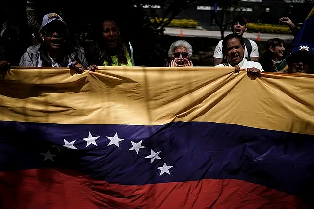 Demonstrators holding a Venezuelan flag outside that nation’s consulate in Bogata, Colombia