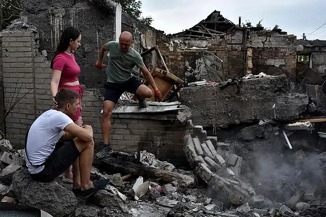 A couple sit in front of their house destroyed by a Russian strike in Zaporizhzhia, Ukraine 