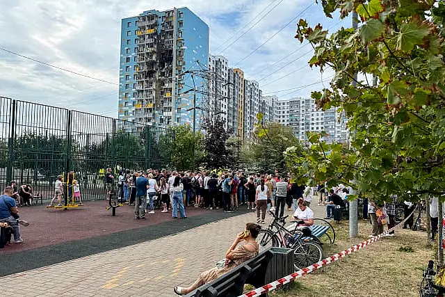 People gather to talk to local officials at the site of the damaged residential building, following an alleged Ukrainian drone attack in Ramenskoye, outside Moscow, Moscow region