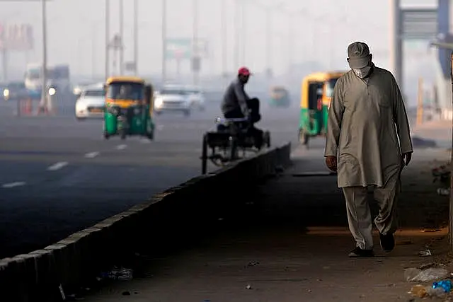 A man wears a face mask by a city street