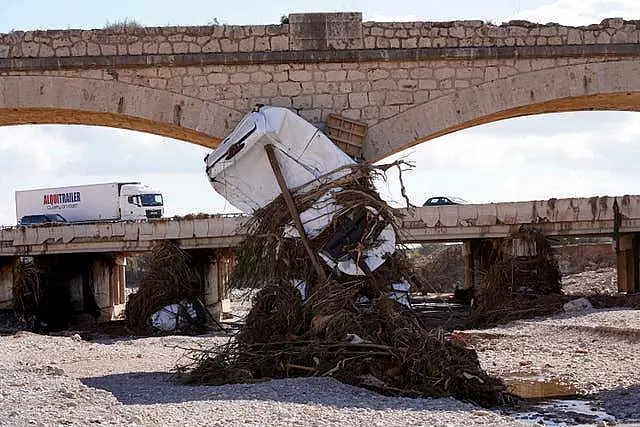 A car sits beneath a bridge after floods on the outskirts of Valencia