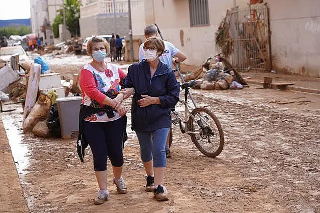 Two women hold hands after floods in Massanassa, just outside of Valencia