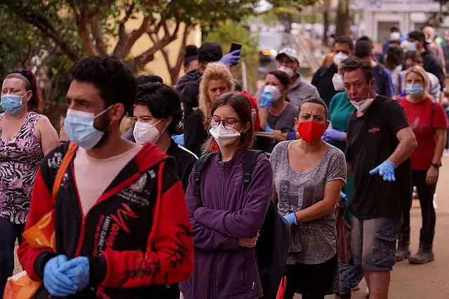 People queue outside a school used as a distribution centre