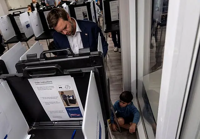 Republican vice presidential nominee Senator JD Vance votes with his son at the St Anthony of Padua Maronite Catholic Church on Election Day in Cincinnati