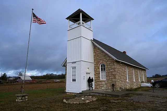 Autumn Liska carries her son Grayson, three, as she arrives at the 146-year-old Buck Creek School to cast her ballot on Election Day in rural Perry, Kansas 