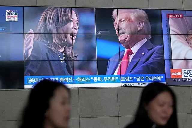 A screens shows images Kamala Harris and Donald Trump 