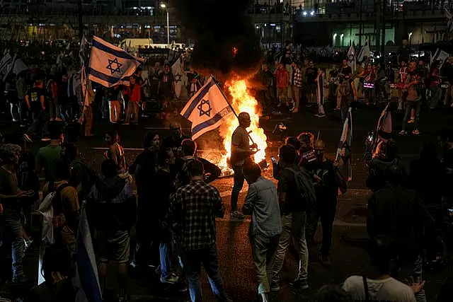 Israelis in Tel Aviv light a bonfire during a protest after Prime Minister Benjamin Netanyahu has dismissed his defence minister Yoav Gallant in a surprise announcement 