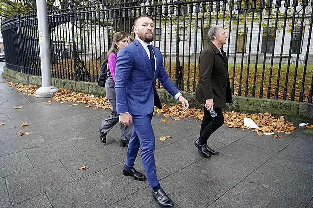 Conor McGregor walks down the street in a suit