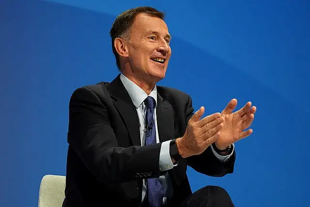 Jeremy Hunt smiles as he gestures with his hands