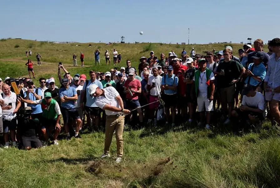 Rory McIlroy hacks out of the rough on the first at Royal St George's