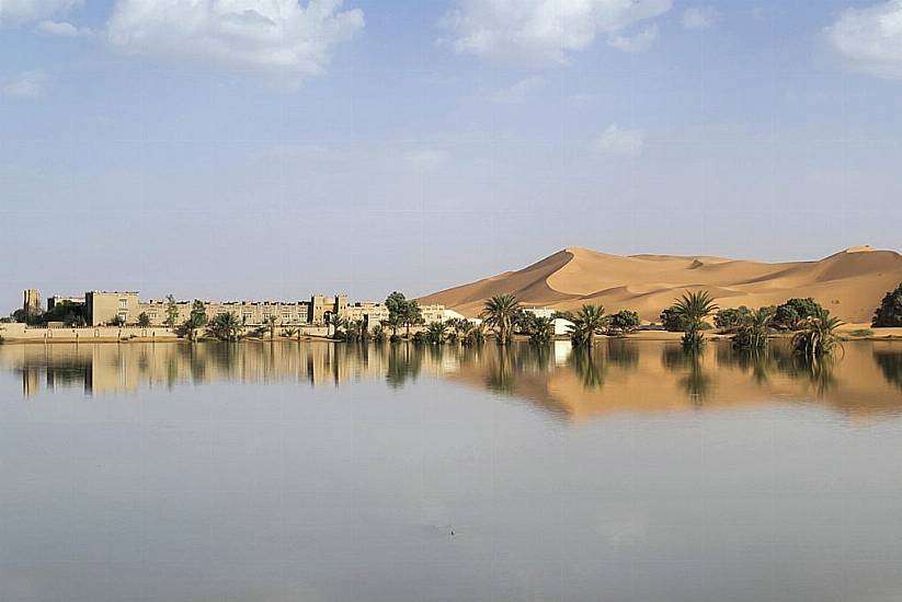 Water Gushes Through Palm Trees And Sand Dunes After Rare Rain In Sahara Desert