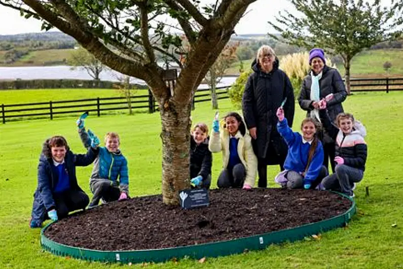 Local school children and Mary McAleese plant dozens of flowers to remember the holocaust